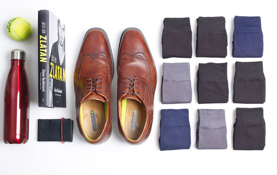 Bildet viser ulike typer sokker til herre samt et par sko og en bok
